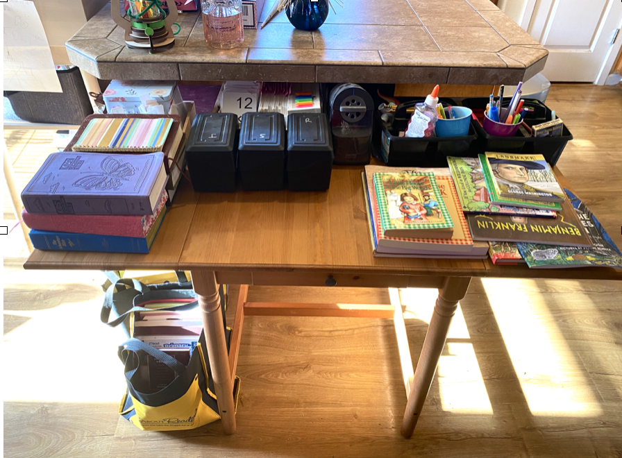 Table nearby with homeschool supplies needed daily. Realistic homeschool organization!